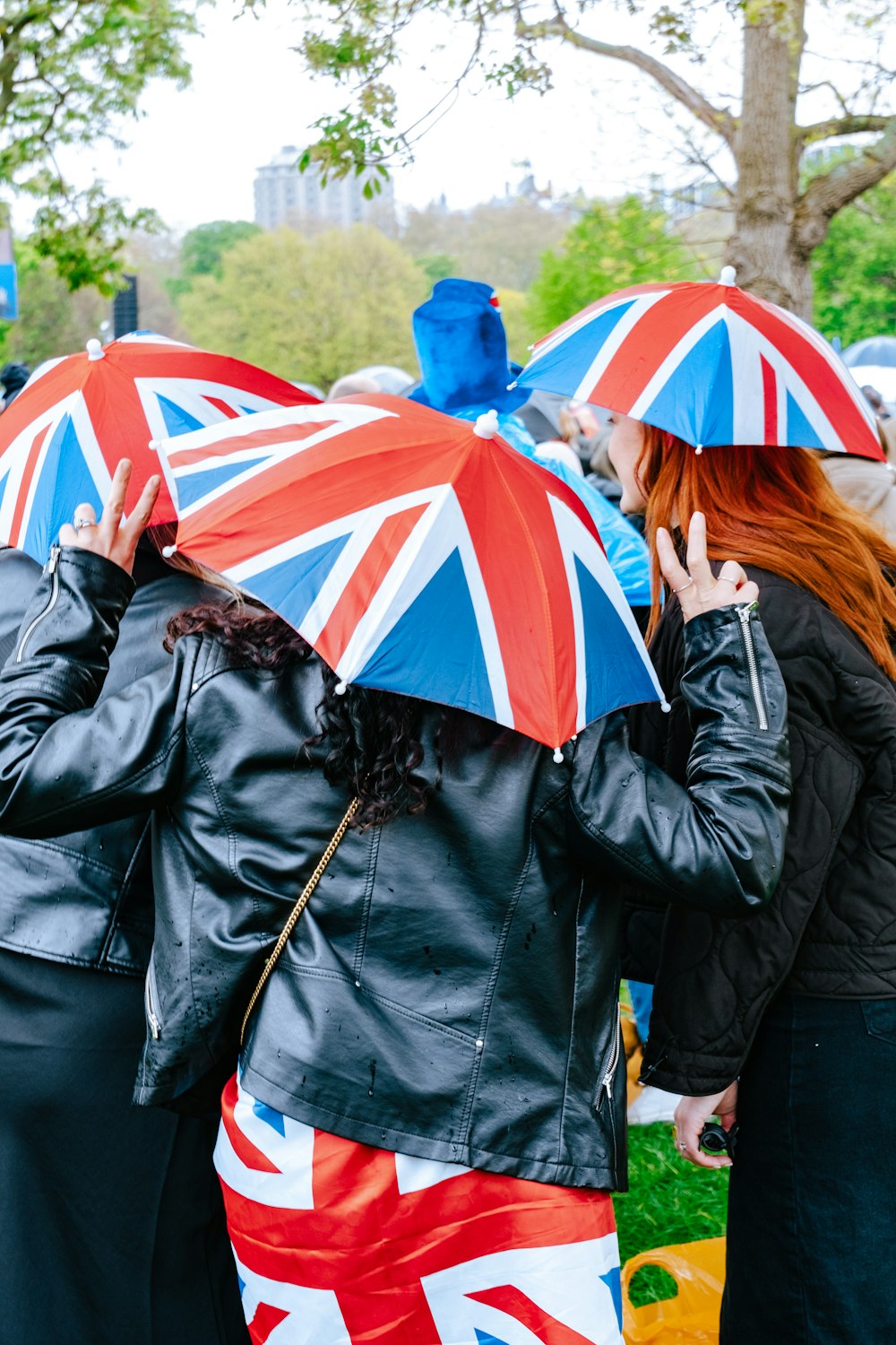a group of people standing around each other holding umbrellas