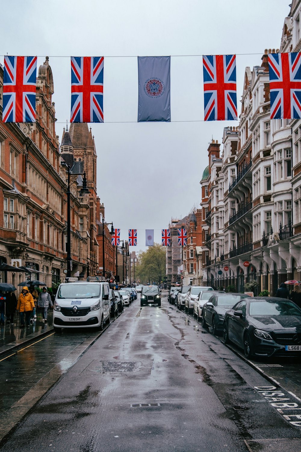 a wet street with cars parked on the side of it