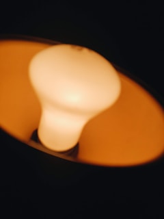 Close-up of a contemporary LED bulb glowing warmly against a dark background