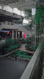 Modern shopping mall with green rooftop garden and solar panels.