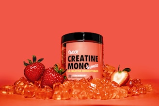 a jar of creatin monoc next to some strawberries
