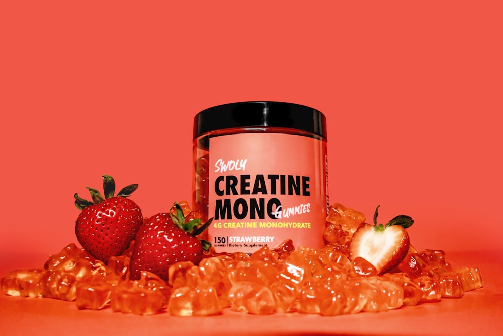 a jar of creatin monoc next to some strawberries