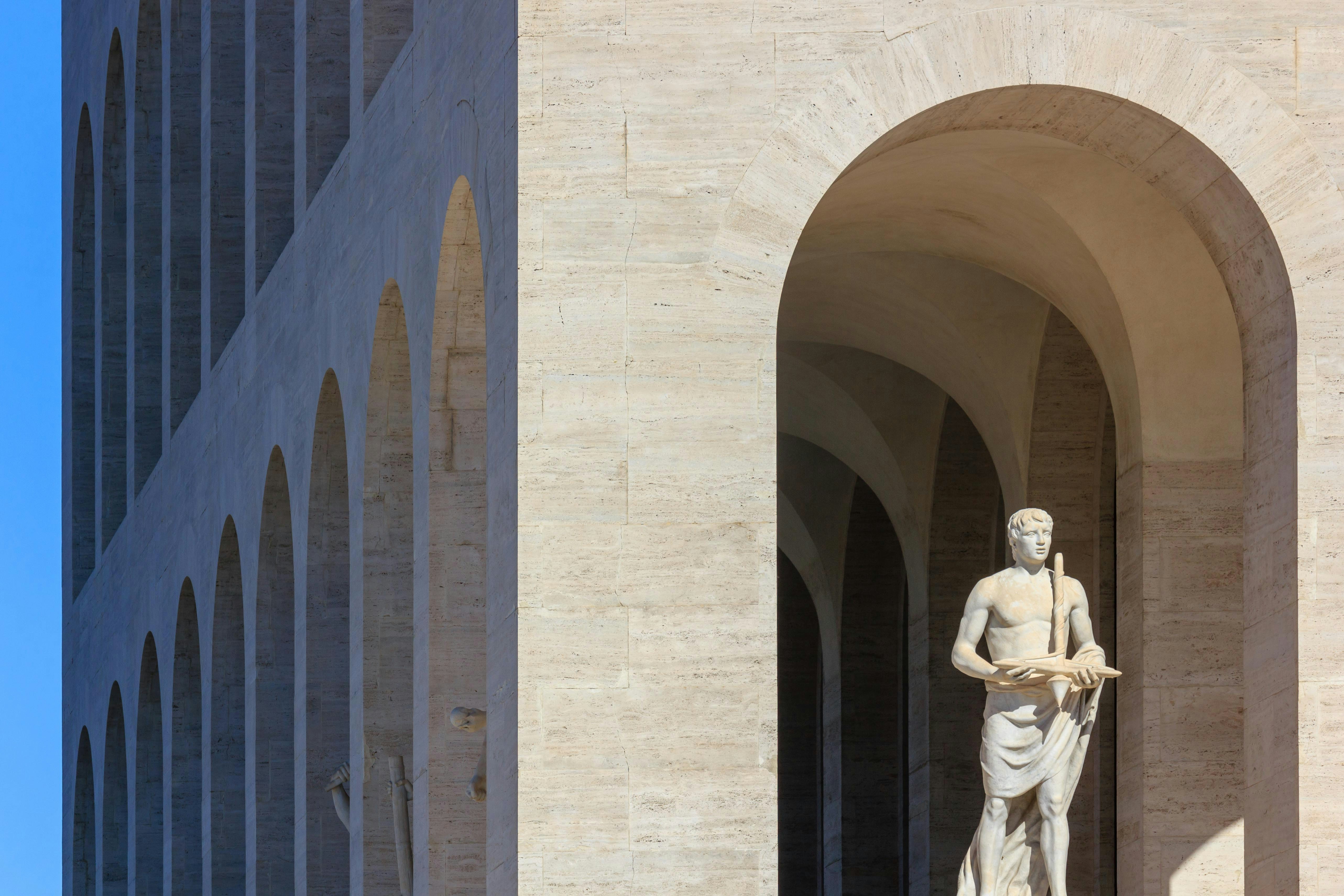 a statue of a man standing in front of a building