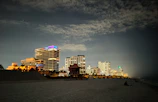Nighttime view of Myrtle Beach skyline with illuminated high-rises and lively streets.