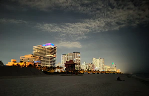 Nighttime view of Myrtle Beach skyline with illuminated high-rises and lively streets.