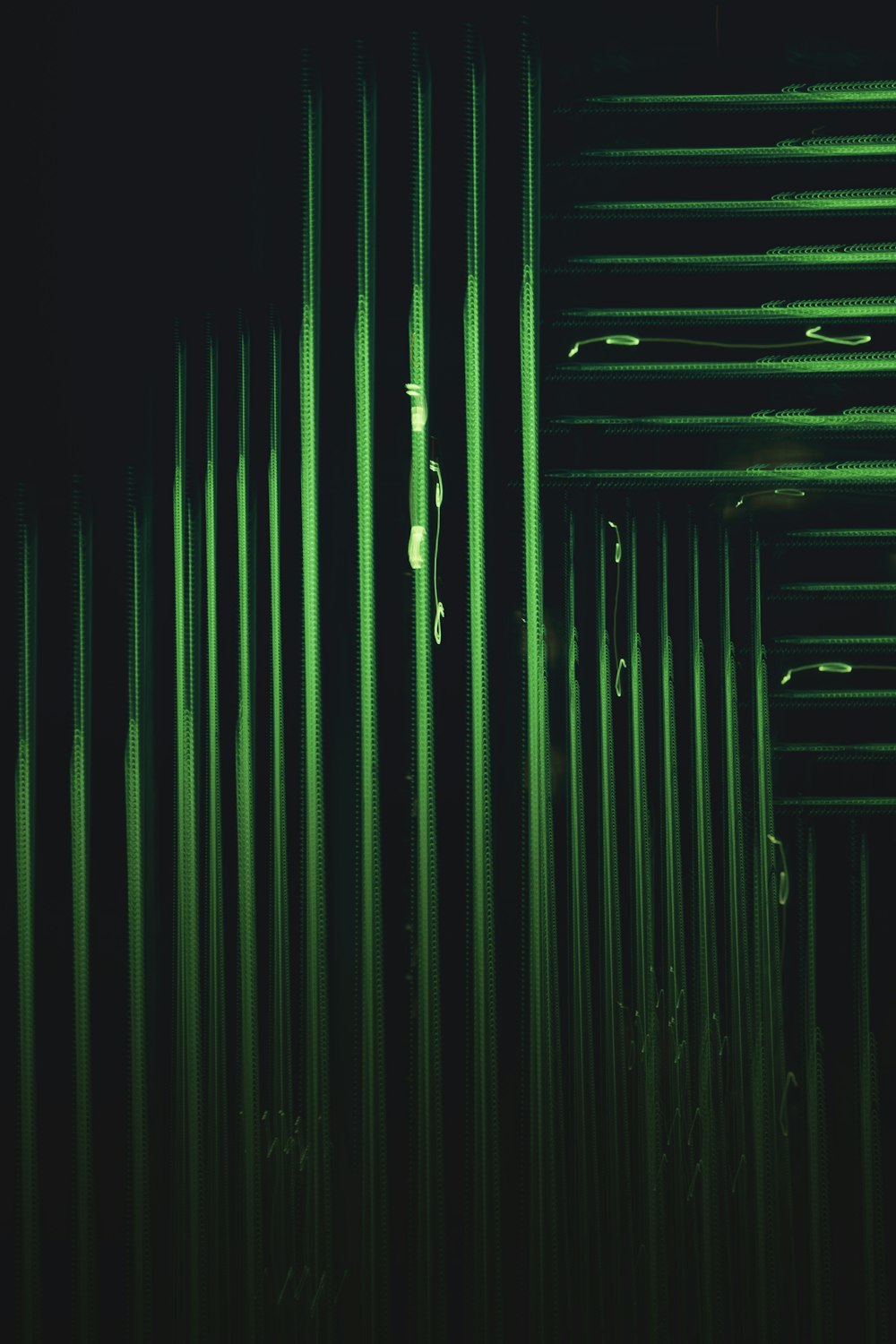 a dark room filled with lots of green pipes
