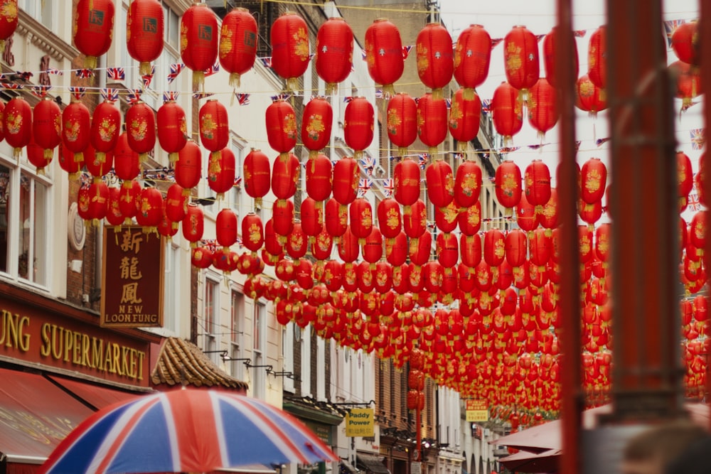 a street filled with lots of red lanterns hanging from the side of buildings