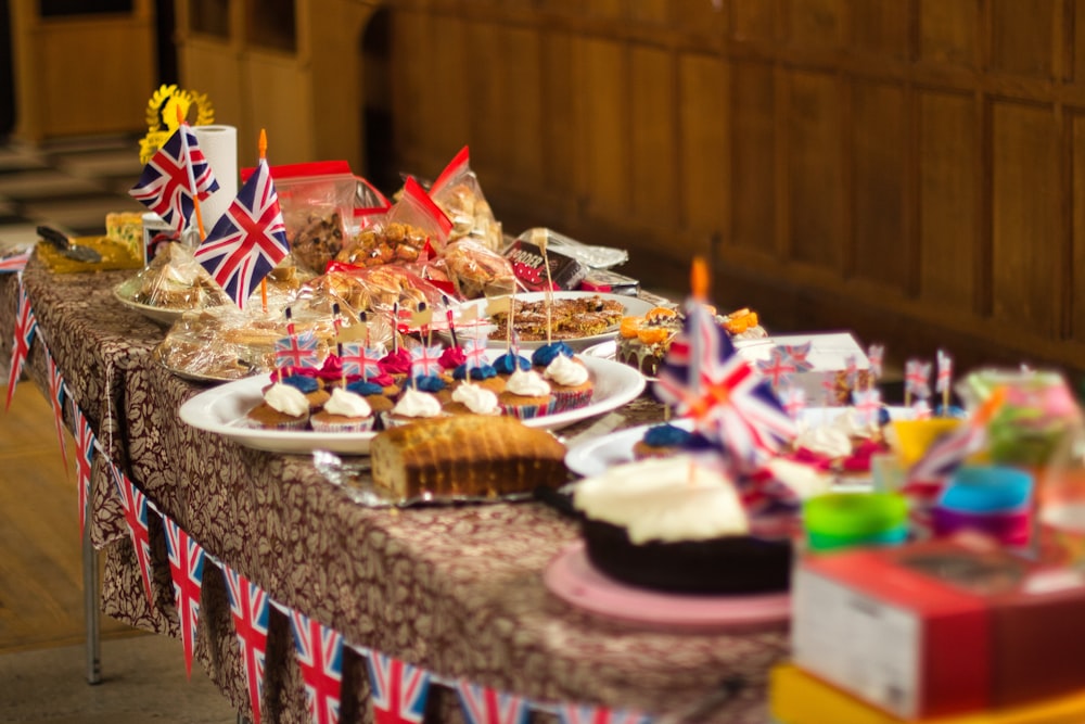 a table topped with lots of cakes and cupcakes