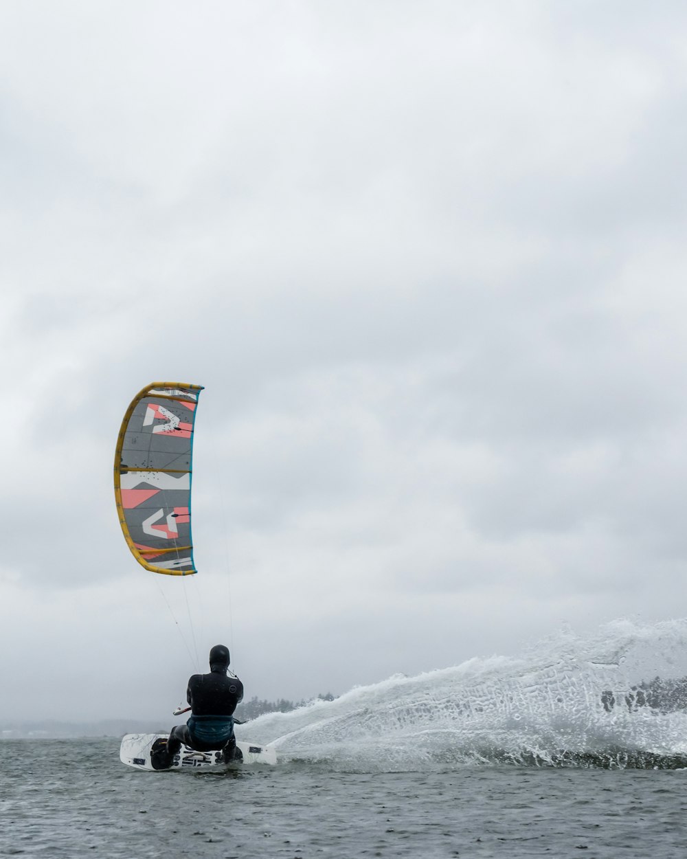 a man riding a surfboard with a kite attached to it