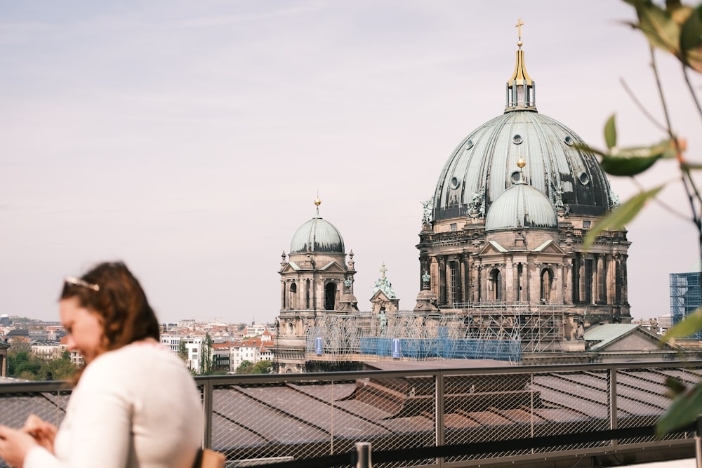 a woman standing on top of a roof next to a tall building