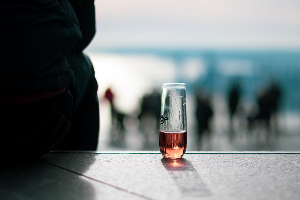 a glass filled with liquid sitting on top of a table