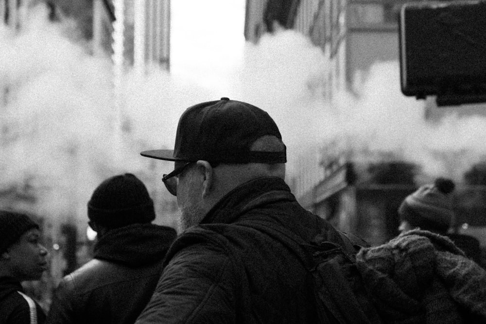 a man in a baseball cap standing in front of a crowd of people