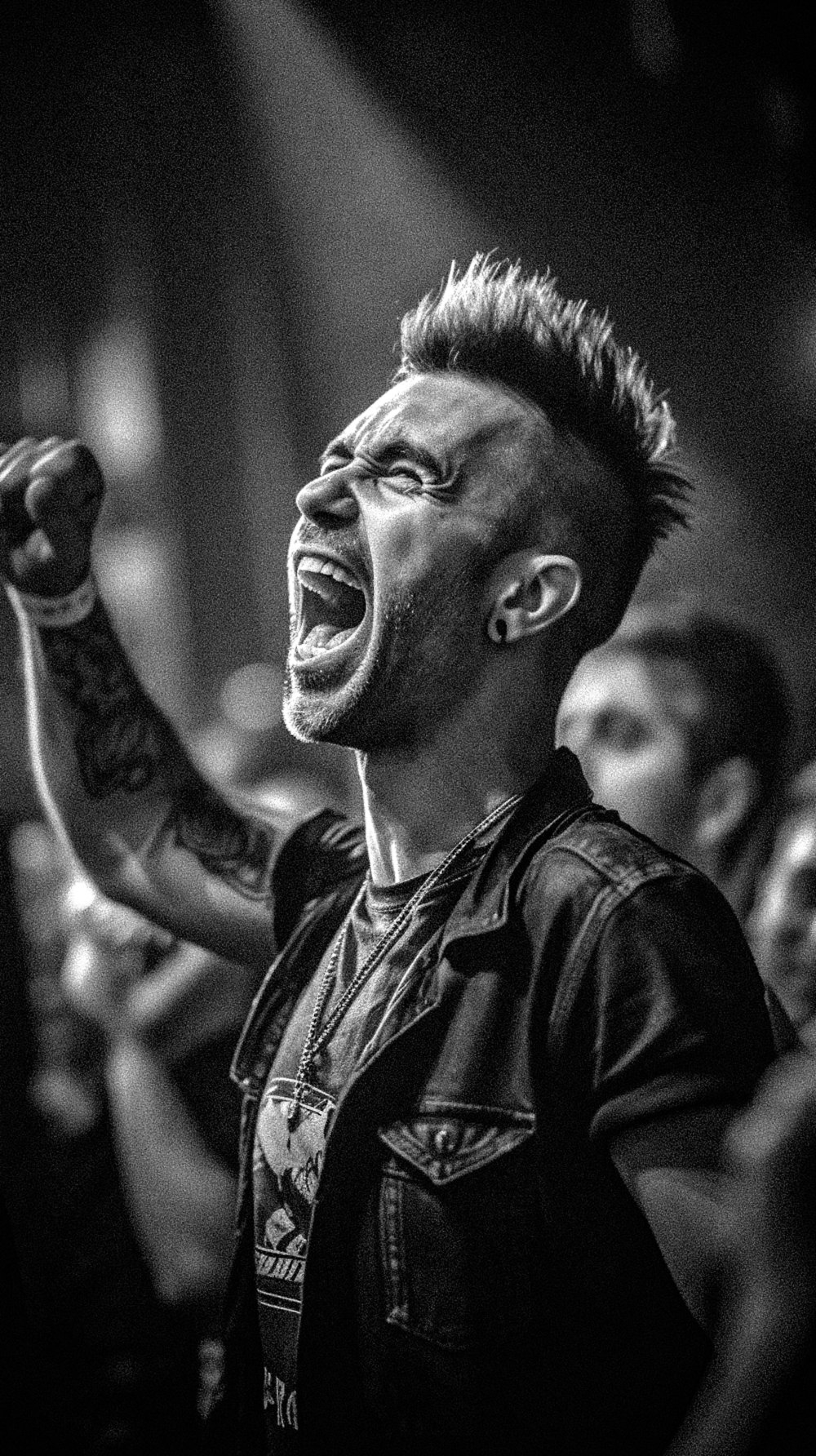 a black and white photo of a man singing into a microphone