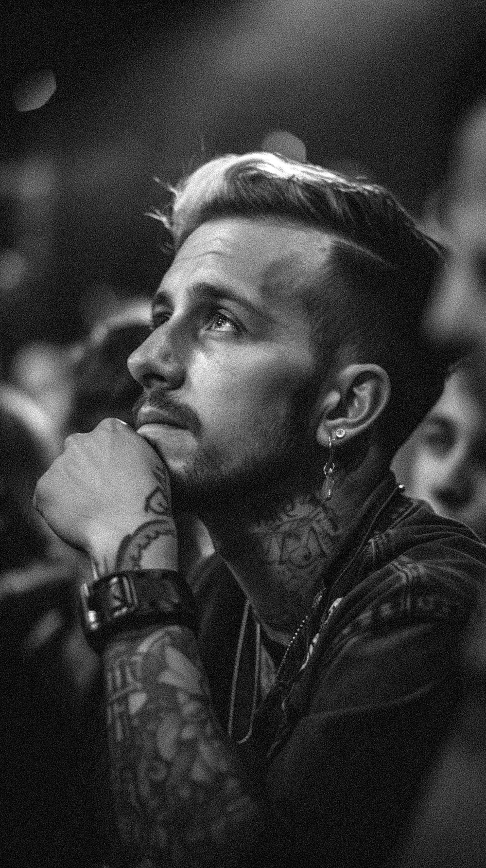 a black and white photo of a man with tattoos