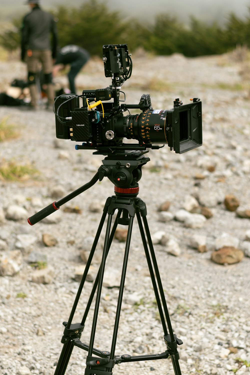 a camera on a tripod on a gravel road
