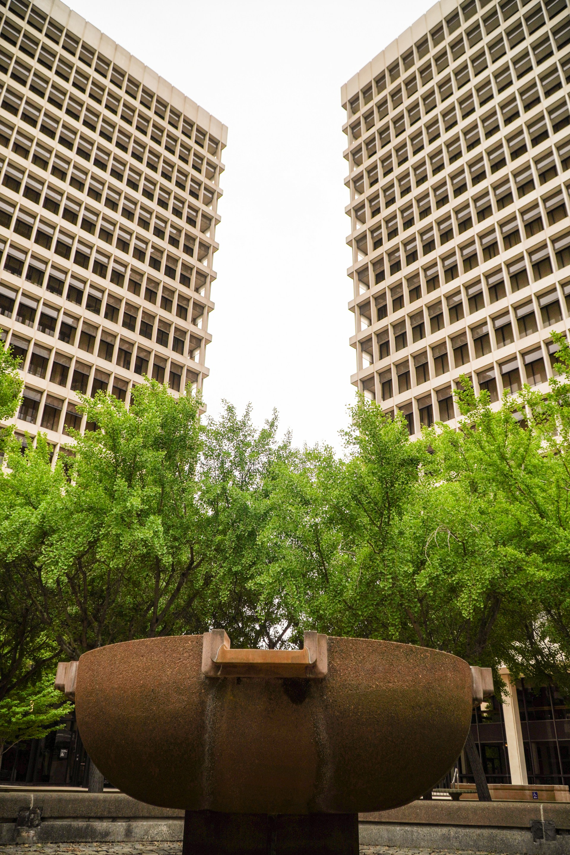 a large fountain in front of two tall buildings