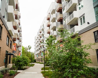 a sidewalk between two buildings with balconies