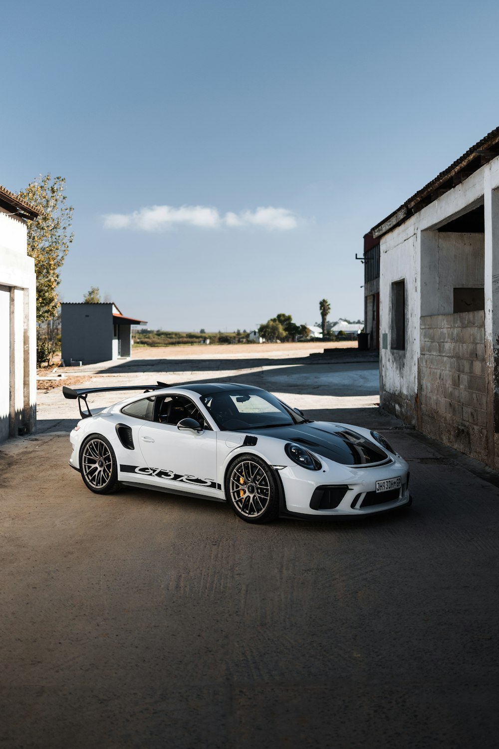 a white sports car parked in front of a building