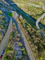 Aerial view of a winding road being built through a green landscape.