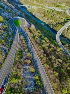 An aerial view of a winding road through a lush green landscape.