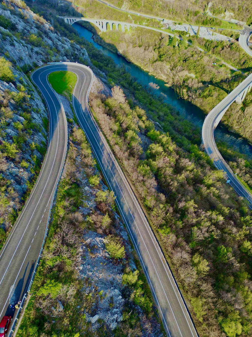 an aerial view of a winding road in the middle of a forest