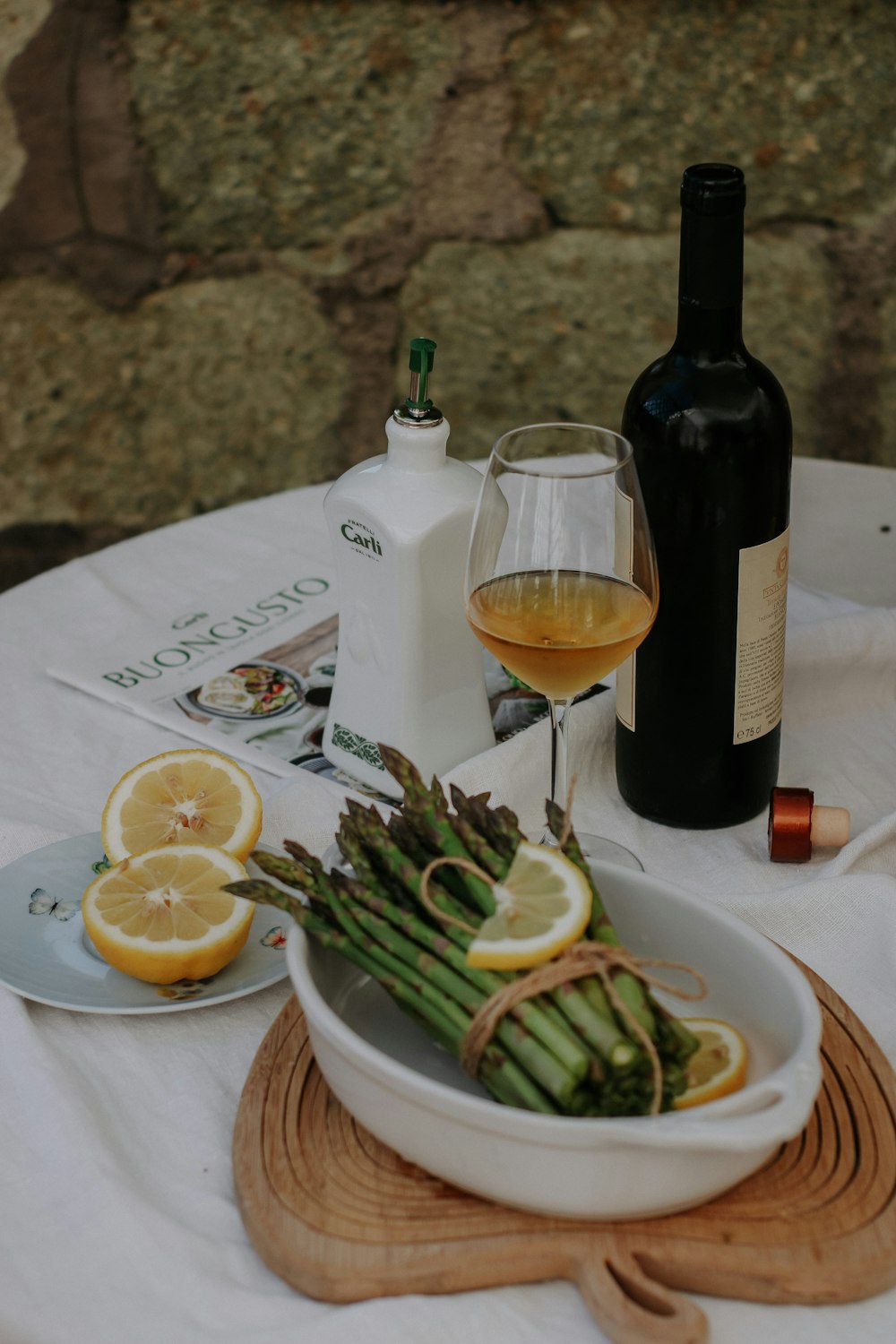 a bowl of asparagus and a glass of wine on a table