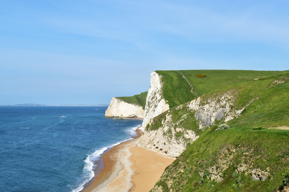 a view of a beach with a cliff in the background