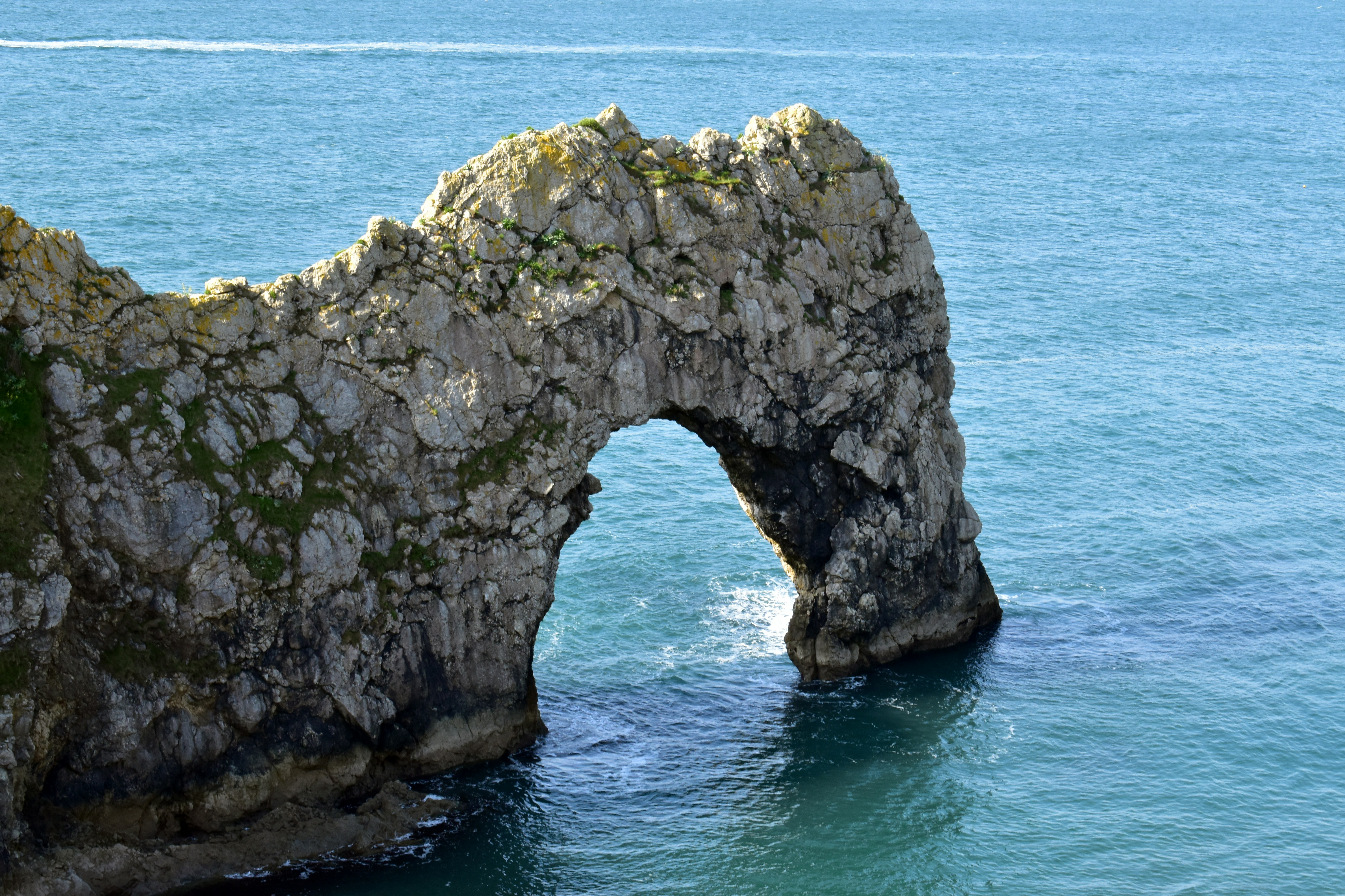 a large rock formation in the middle of a body of water