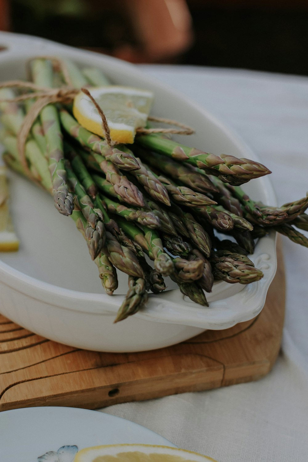 a bunch of asparagus on a plate with lemon wedges