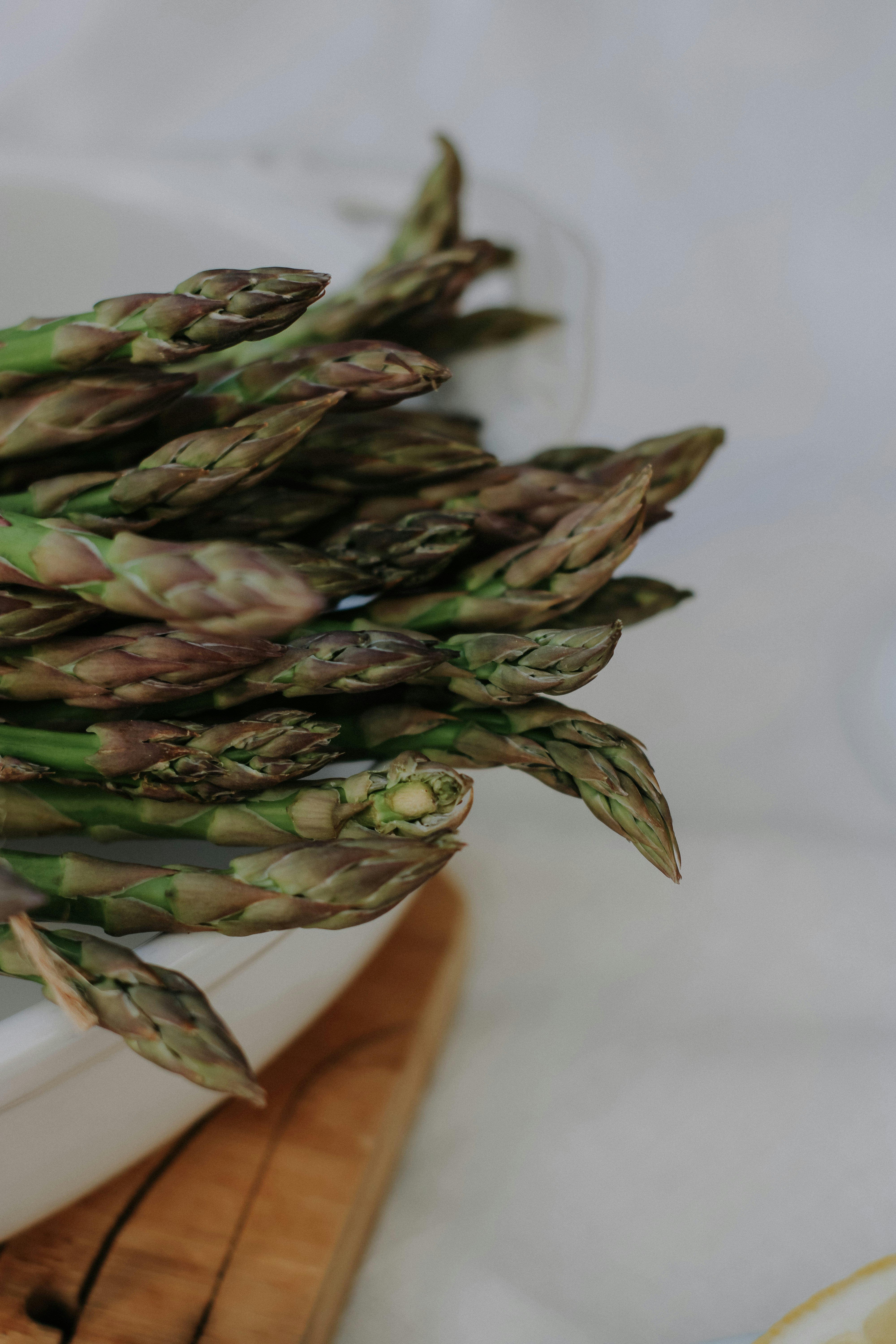 Bundle of fresh green asparagus spears tied with twine on a rustic wooden board