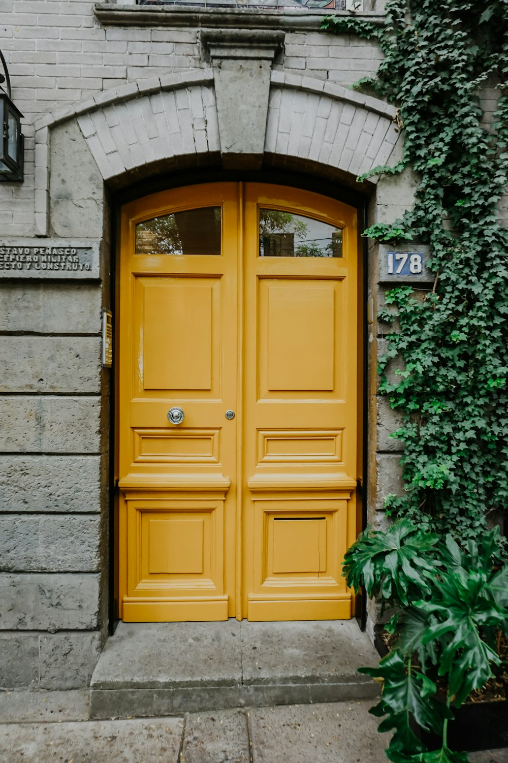 a yellow door is open on a brick building