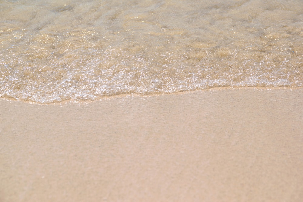 a close up of the sand and water of a beach