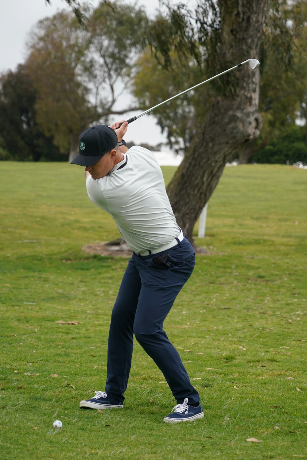 a man swinging a golf club at a ball