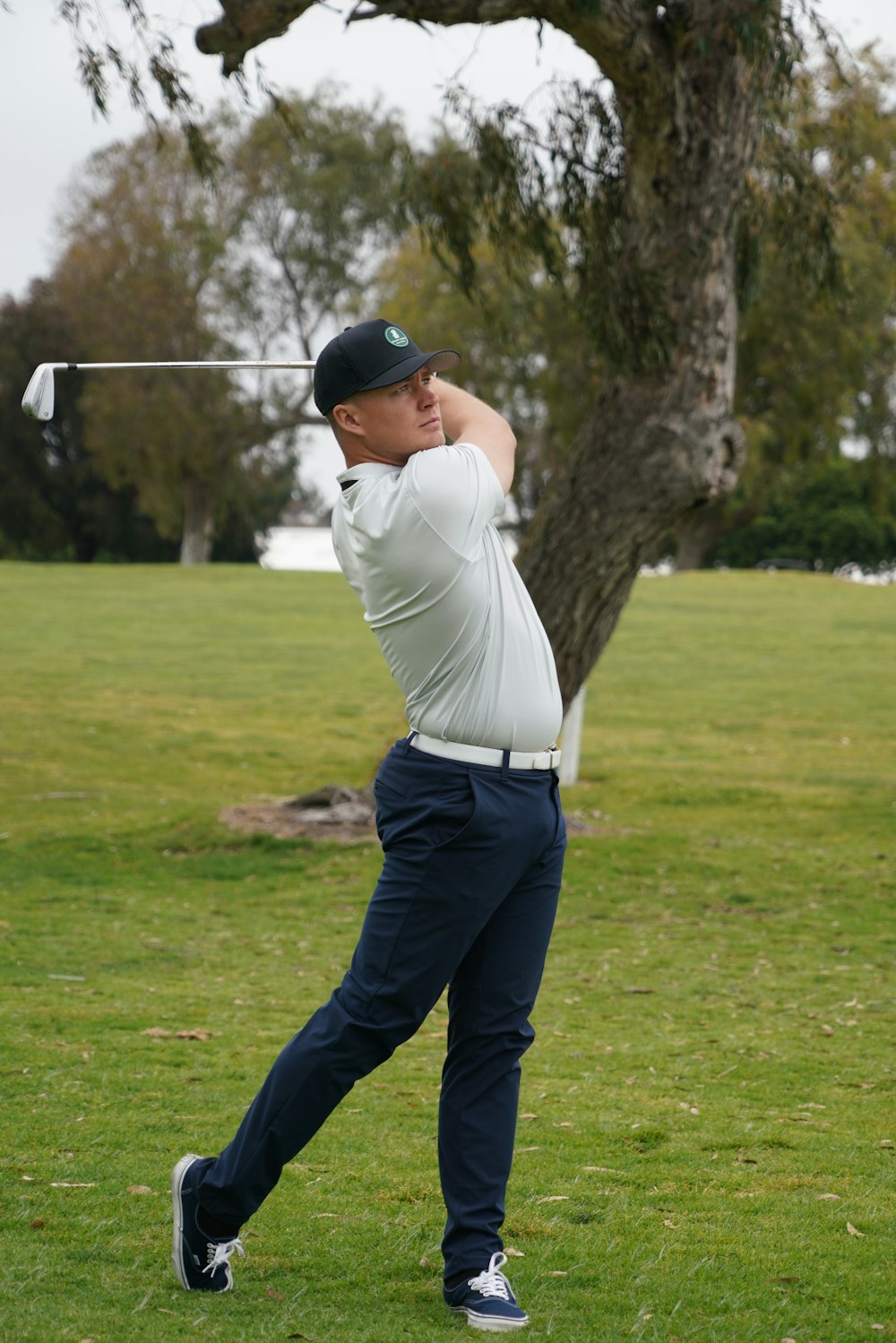 Un hombre balanceando un palo de golf en una pelota