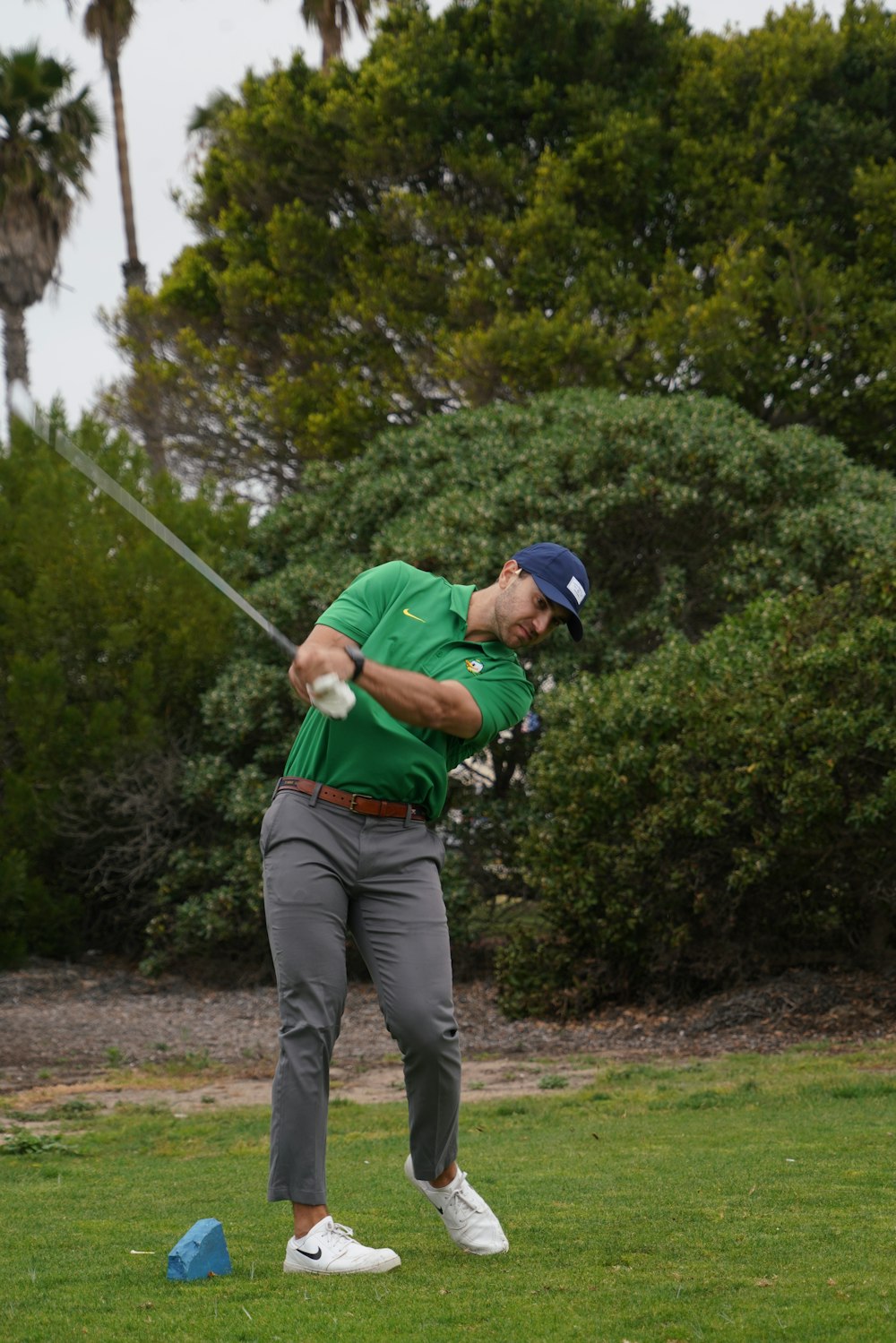 a man swinging a golf club at a ball