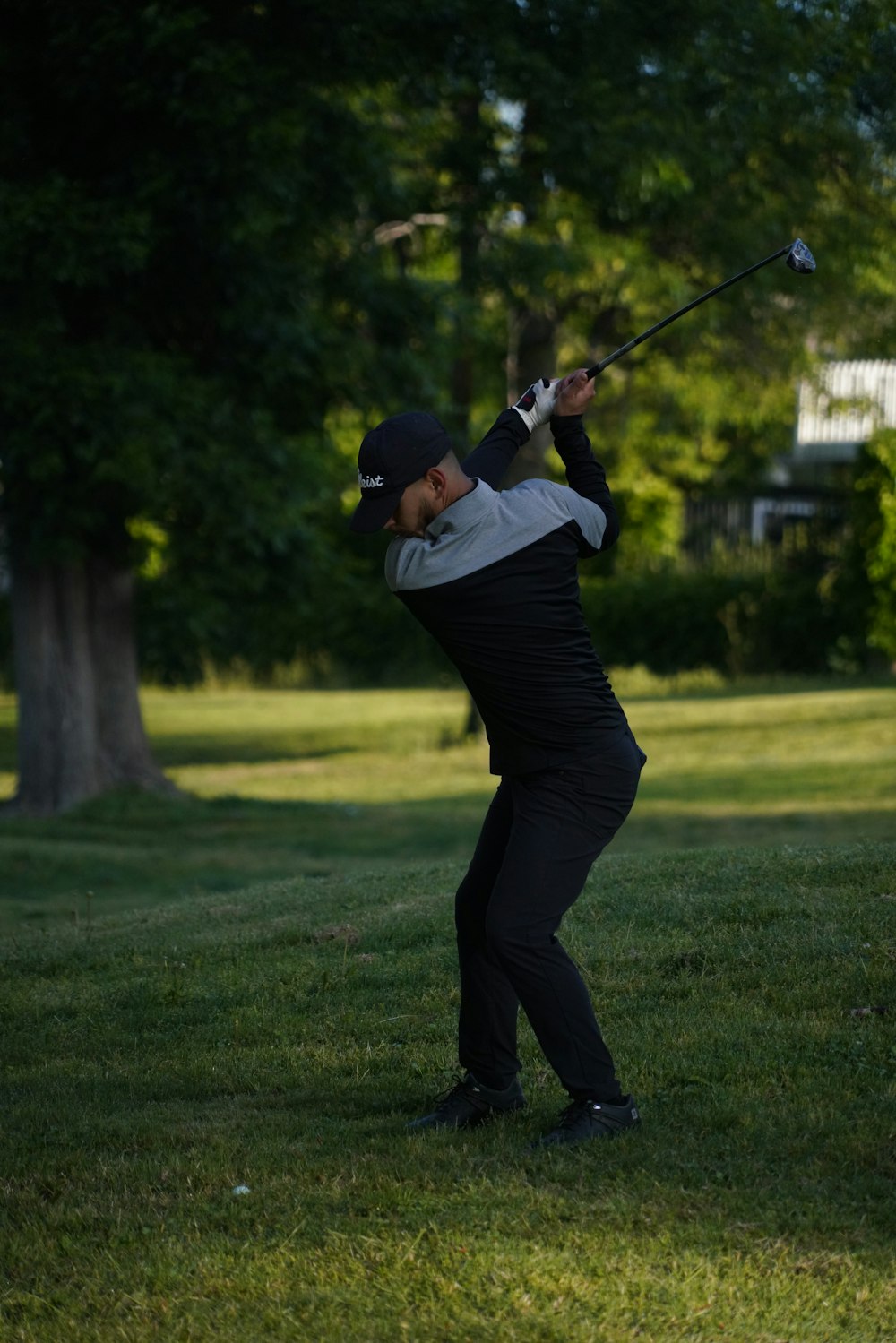 a man swinging a golf club on a lush green field