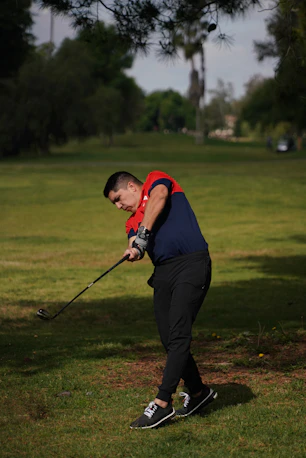 a man swinging a golf club at a ball
