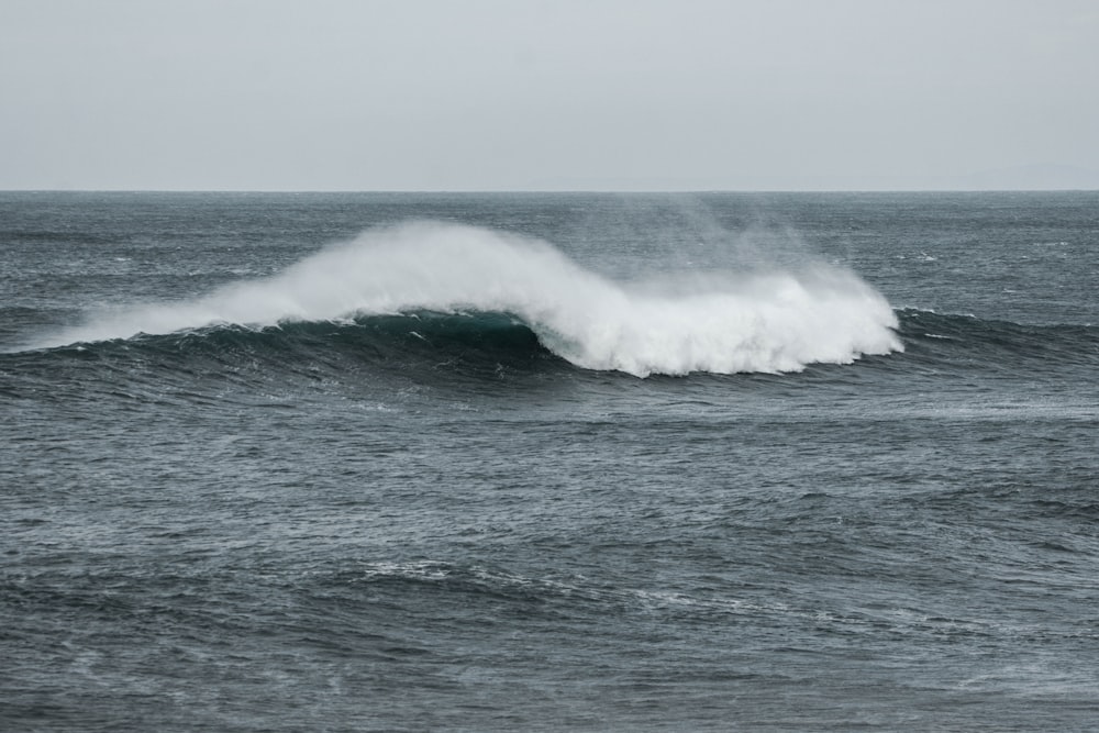 a large wave in the middle of the ocean