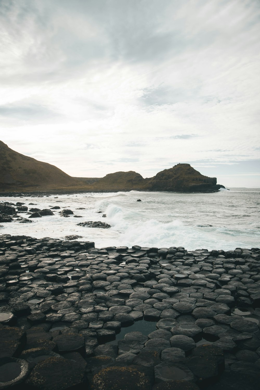 a large body of water sitting next to a rocky shore