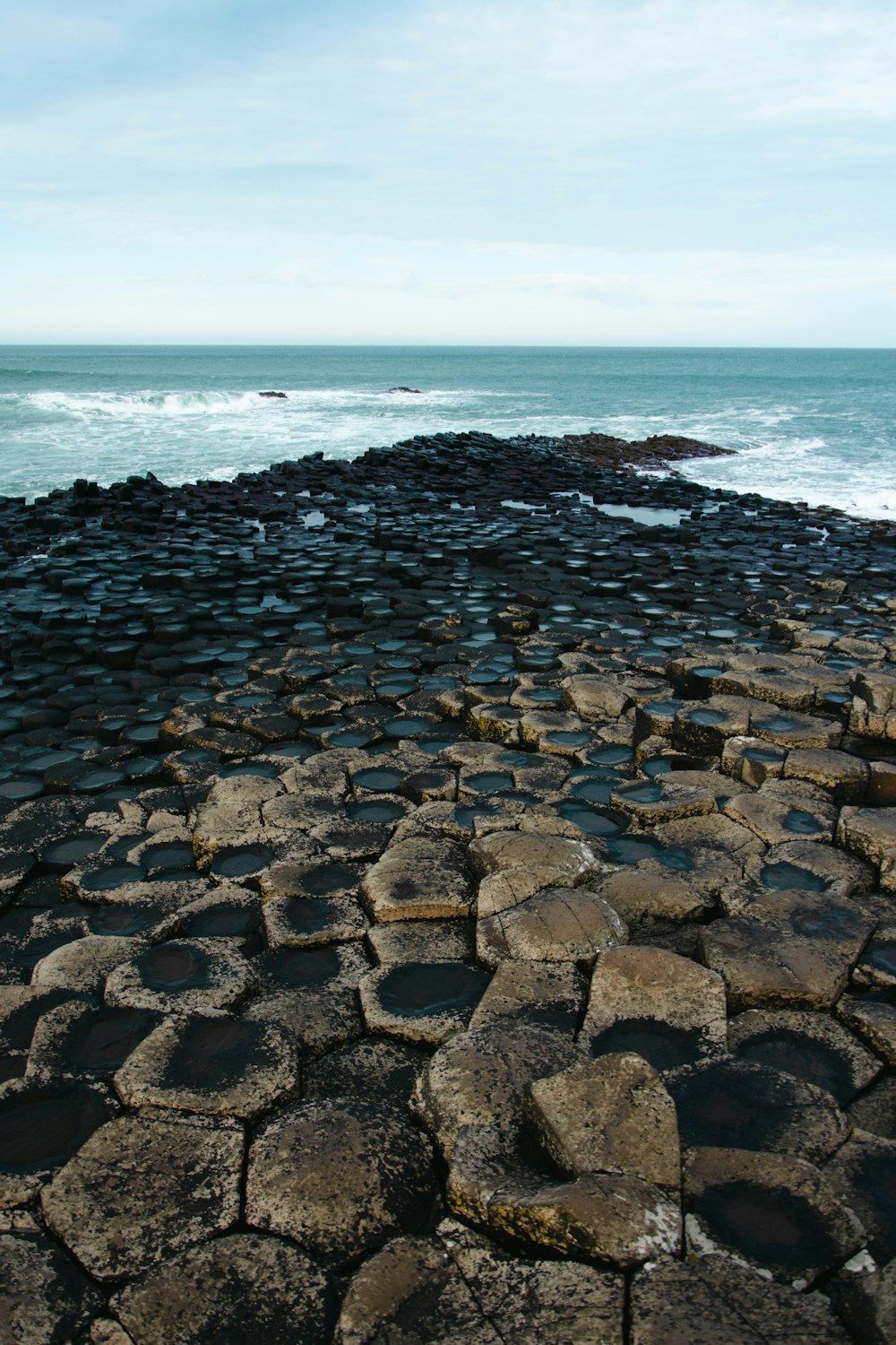 a large rock formation next to the ocean