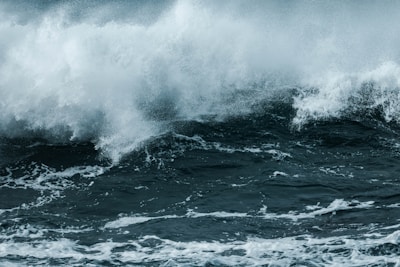 Powerful ocean waves crash with high-energy spray and foam, capturing the dynamic and turbulent nature of the sea.