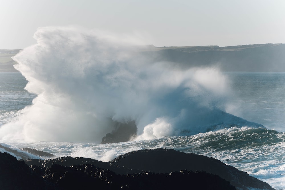 a large wave crashing into the shore of the ocean