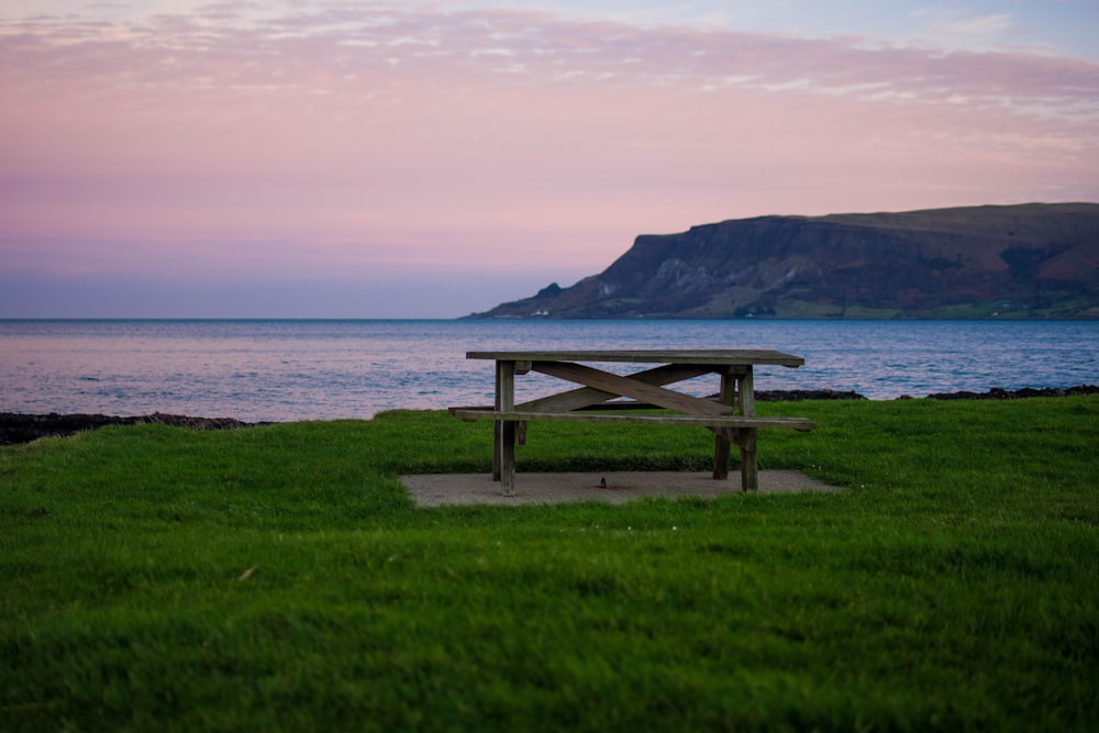 a picnic table sitting on top of a lush green field