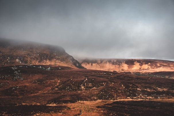 A cinematic landscape photo with a slow zoom effect on mist rolling over dark hills.