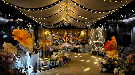A beautifully decorated event space with elegant lighting and floral arrangements.