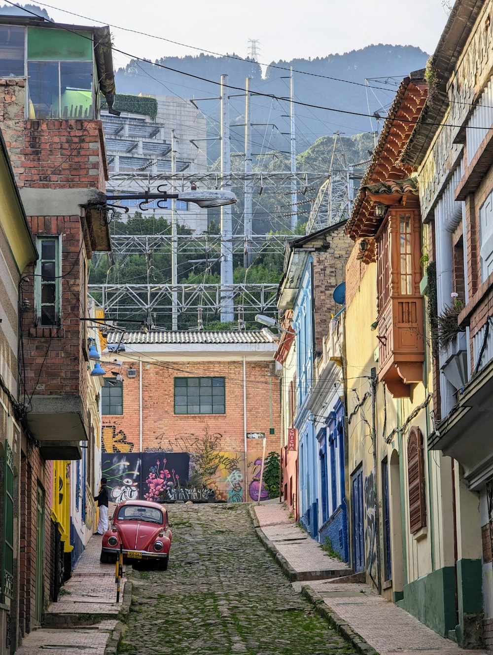 a red car parked on a narrow street