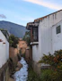 a small stream running between two white buildings