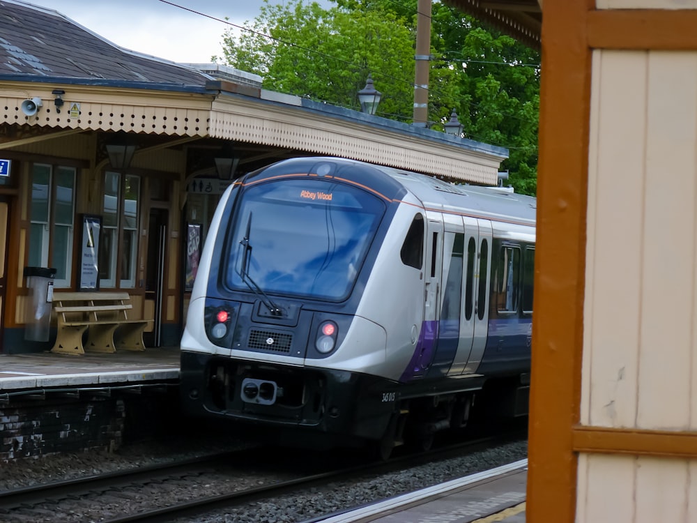 a silver train pulling into a train station