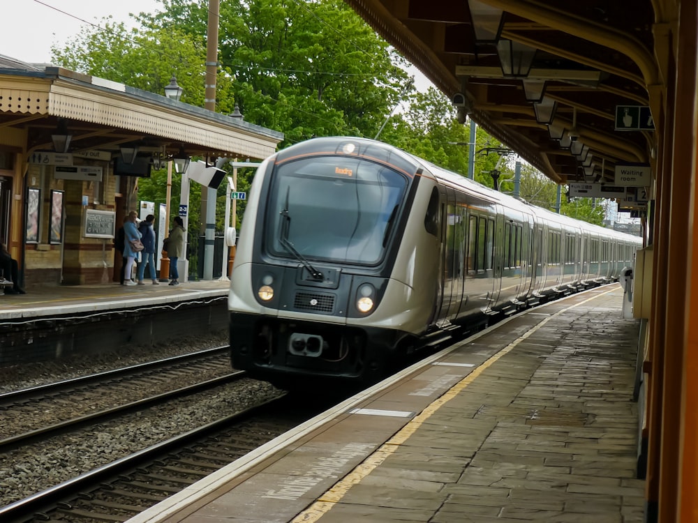 a silver train pulling into a train station