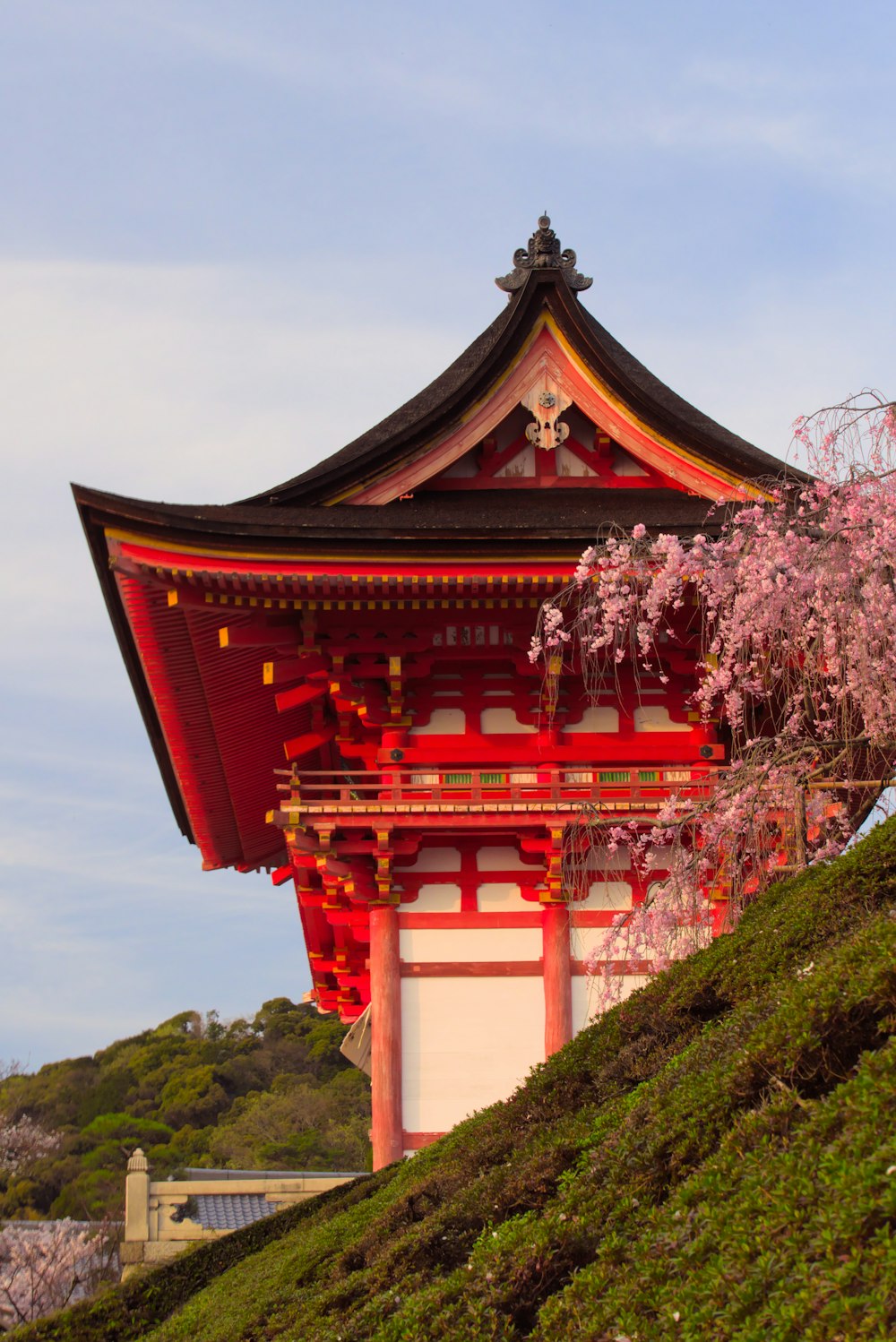 Un alto edificio rojo y blanco con un árbol frente a él